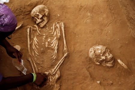 FILE PHOTO: An American archaeology student unearths a skeleton during excavation works at the first-ever Philistine cemetery at Ashkelon National Park