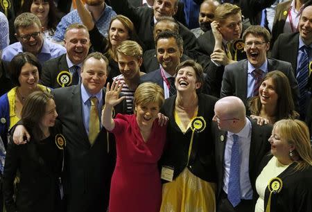 Nicola Sturgeon, leader of the Scottish National Party, waves surrounded by candidates and supporters at a counting centre in Glasgow, Scotland, May 8, 2015. REUTERS/Russell Cheyne