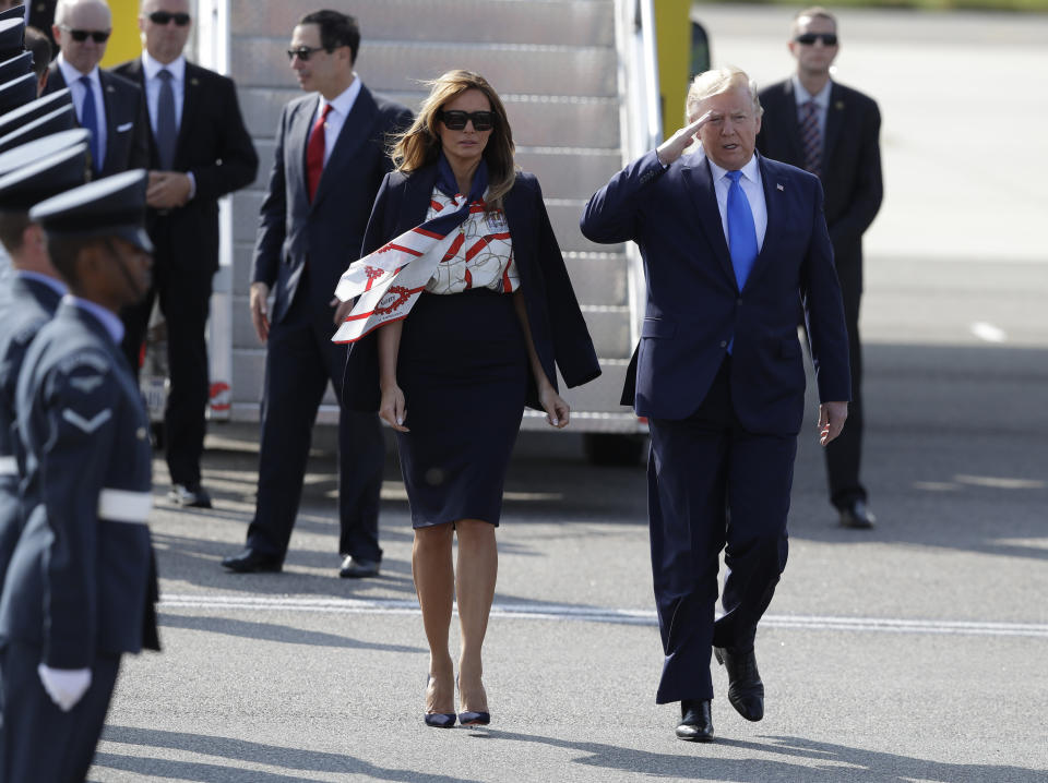 President Donald Trump salutes an honor guard as he and first lady Melania Trump arrive at Stansted Airport in England, Monday, June 3, 2019 at the start of a three day state visit to Britain. (AP Photo/Kirsty Wigglesworth)