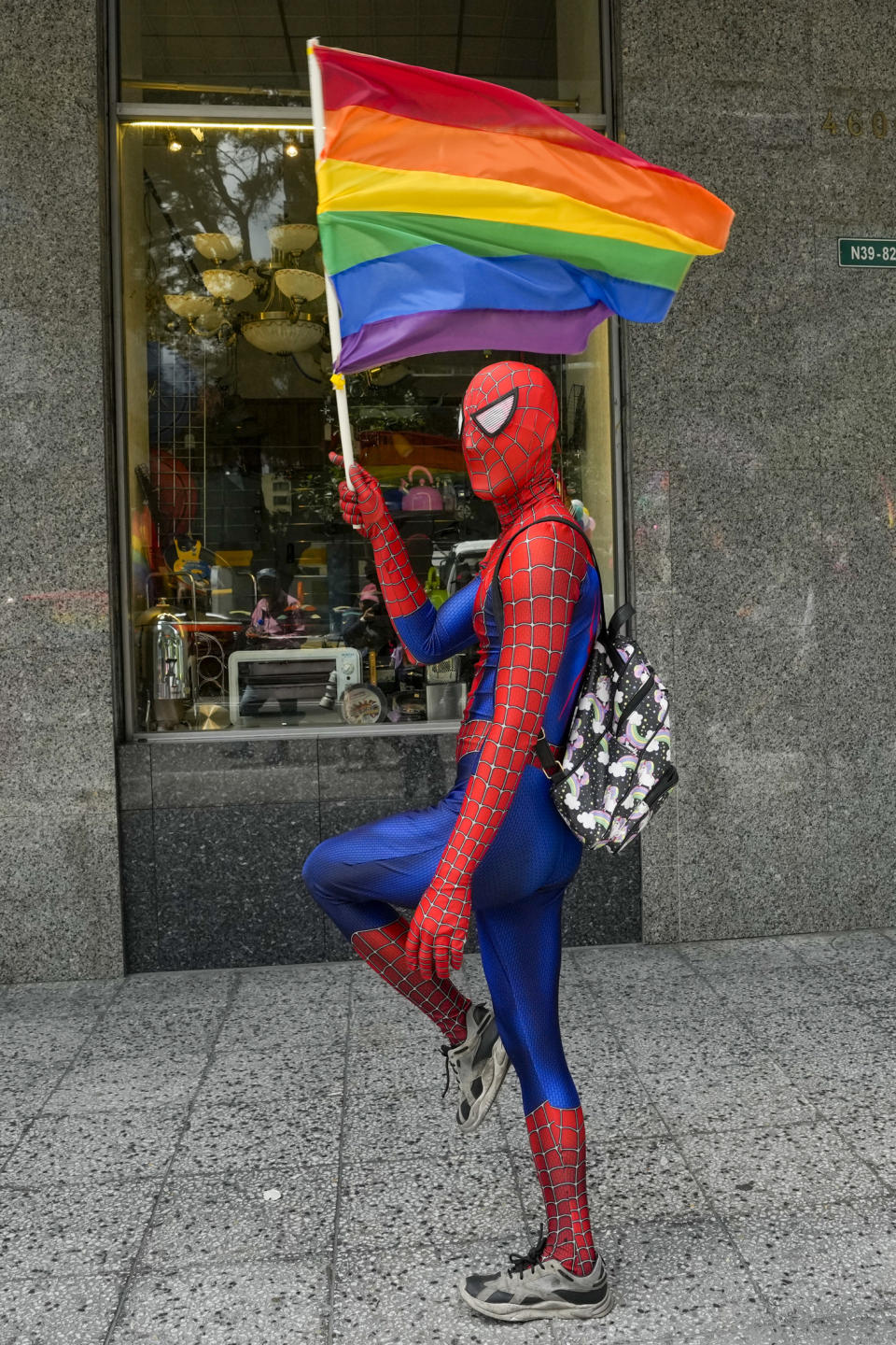 Una persona, disfrazada de Spiderman y ondeando una bandera arcoiris, participa en el Desfile del Orgullo Gay en Quito, Ecuador, el 22 de junio de 2024. (AP Foto/Dolores Ochoa)