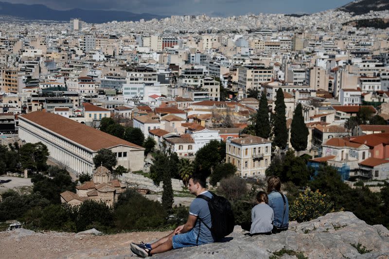 Una familia disfruta de un día cálido en la colina del Areópago cerca de la Acrópolis en Atenas, Grecia