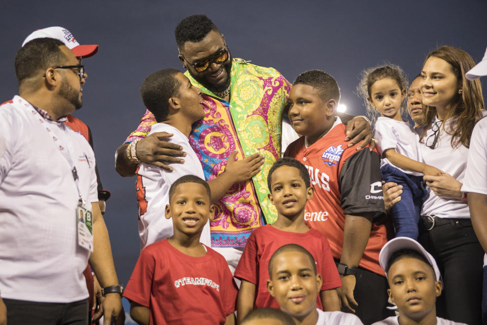 Legendary Boston Red Sox slugger David Ortiz poses for a photo with with youth from the David Ortiz Children's Fund after making a surprise appearance at the Day of Legends baseball event at the Quisqueya Stadium, in Santo Domingo, Dominican Republic, Sunday, Dec. 8, 2019. The Dominican-American retired professional baseball player was shot in the back in his native country six months ago by a hired gunman who drove up on a motorcycle and fired at close range, hitting him in the torso. They said the intended target was another man. (AP Photo/Tatiana Fernandez)