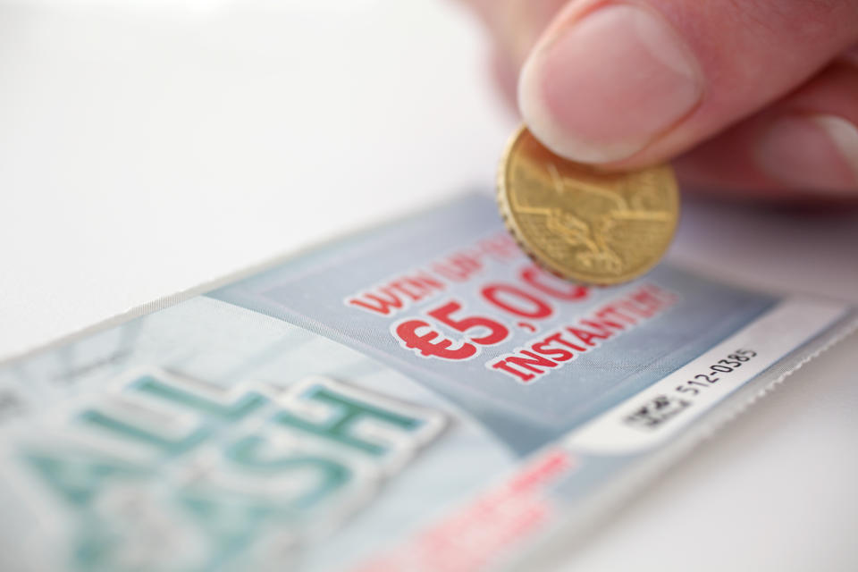 Coin scratching a lottery scratch card