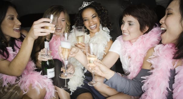 Multi-ethnic bachelorette party toasting with champagne