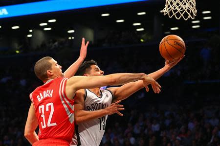 Apr 1, 2014; Brooklyn, NY, USA; Brooklyn Nets guard Jorge Gutierrez (13) shoots the ball while being defended by Houston Rockets guard Francisco Garcia (32) during the fourth quarter at Barclays Center. The Nets defeated the Rockets 105-96. Mandatory Credit: Ed Mulholland-USA TODAY Sports