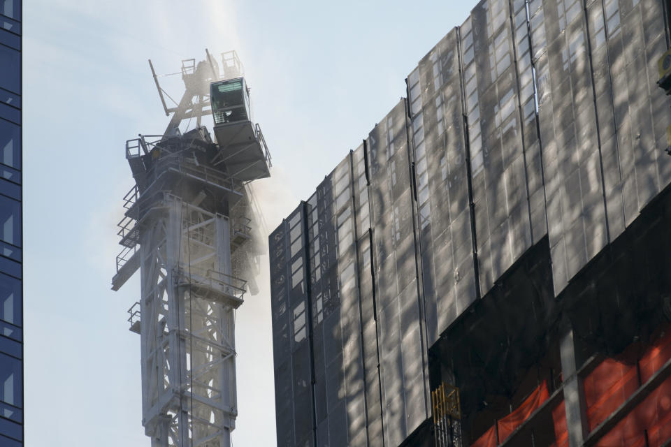 Smoke rises from a construction crane that caught fire in Manhattan, Wednesday, July 26, 2023, in New York. The crane lost its long arm, which smashed against a nearby building, dangled and then plummeted to the street as people ran for their lives on the sidewalk below. Some people suffered minor injuries, but no one died, according to Mayor Eric Adams .(AP Photo/Seth Wenig)