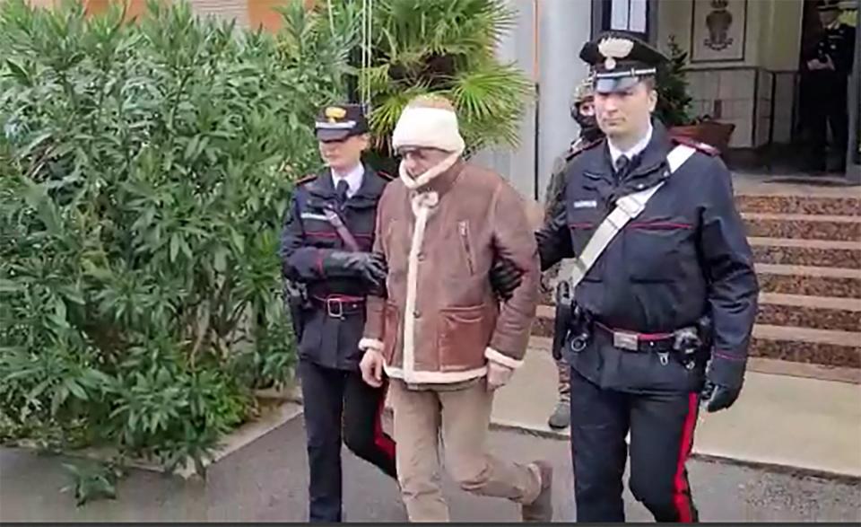 This handout video grab taken and released by the Italian Carabinieri Press Office on January 16, 2023 shows the transfer of Italy's top wanted mafia boss, Matteo Messina Denaro (C) from the Carabinieri police station of San Lorenzo in Palermo, to an undisclosed location, following his arrest in his native Sicily on January 16, 2023 after 30 years on the run. Notorious Sicilian Mafia boss Matteo Messina Denaro, captured in January after three decades on the run, has died in hospital in central Italy, the ANSA news agency reported September 25, 2023. (Photo by Handout / ITALIAN CARABINIERI PRESS OFFICE / AFP)