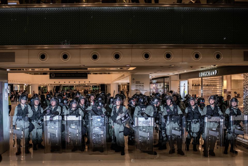 SHA TIN, HONG KONG, HONG KONG SAR, CHINA - 2019/07/14: Riot police push protesters while attending to a wounded police agent, during the protests. Thousands of protesters marched in Sha Tin district as pro-democracy demonstrators continue with weekly rallies on the streets of Hong Kong for the past month, calling for the complete withdrawal of a controversial extradition bill. (Photo by Ivan Abreu/SOPA Images/LightRocket via Getty Images)