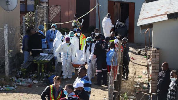 PHOTO: Forensic personnel carry a body out of a township pub in South Africa's southern city of East London on June 26, 2022, after 20 teenagers died. (Str/AFP via Getty Images)