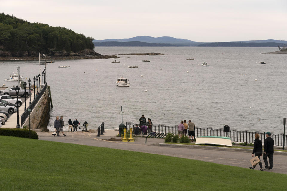 Visitors walk along the waterfront as Hurricane Lee approaches, Friday, Sept. 15, 2023, in Bar Harbor, Maine. With only a few exceptions, most of the area's fishermen have moved their boats to safety before Saturday's storm. (AP Photo/Robert F. Bukaty)