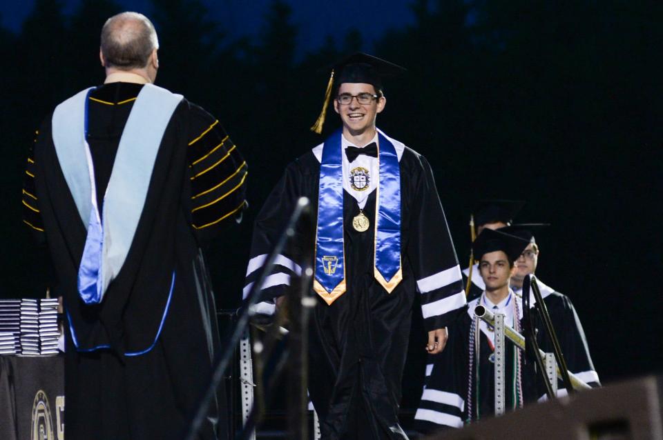 A graduate walks across the stage at the Central Magnet High School commencement ceremony at Siegel High School football stadium on May 14, 2021, in Murfreesboro, Tenn.