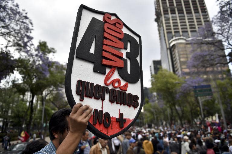 A protester holds a banner reading "43. We want them alive" in Mexico City on March 26, 2015, during a march to mark six months of the disappearance of 43 students from a rural school in Ayotzinapa