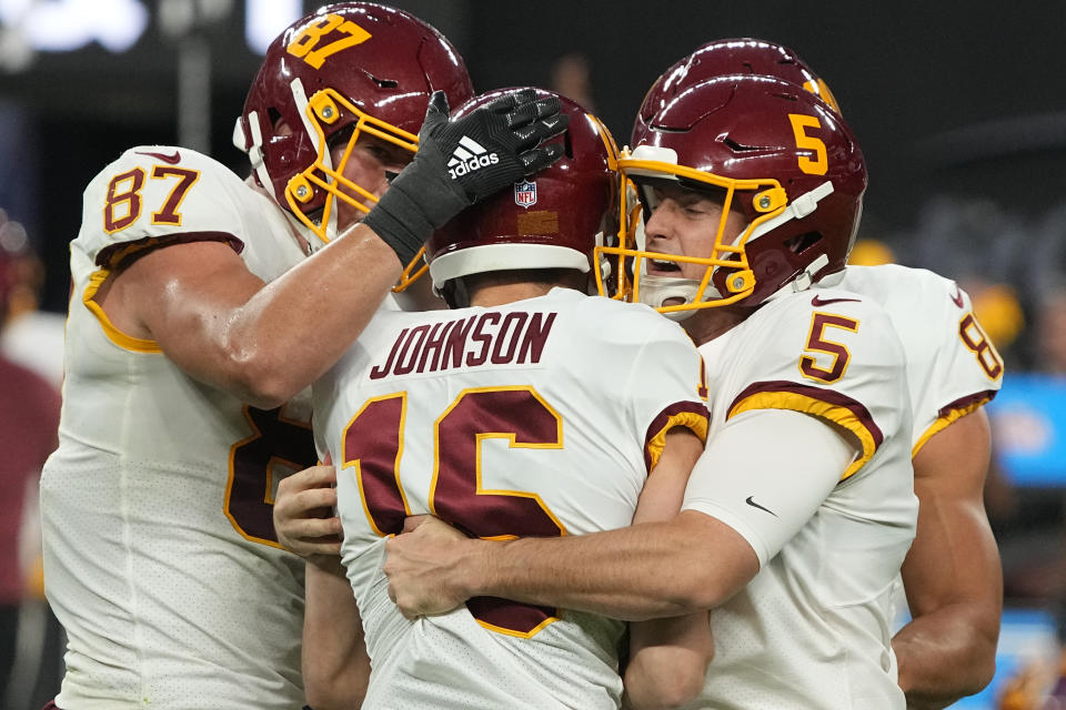 Washington Football Team's Tress Way (5) embraces kicker Brian Johnson after Johnson made a 48-yard field goal against the Las Vegas Raiders during the second half of an NFL football game, Sunday, Dec. 5, 2021, in Las Vegas. (AP Photo/Rick Scuteri)