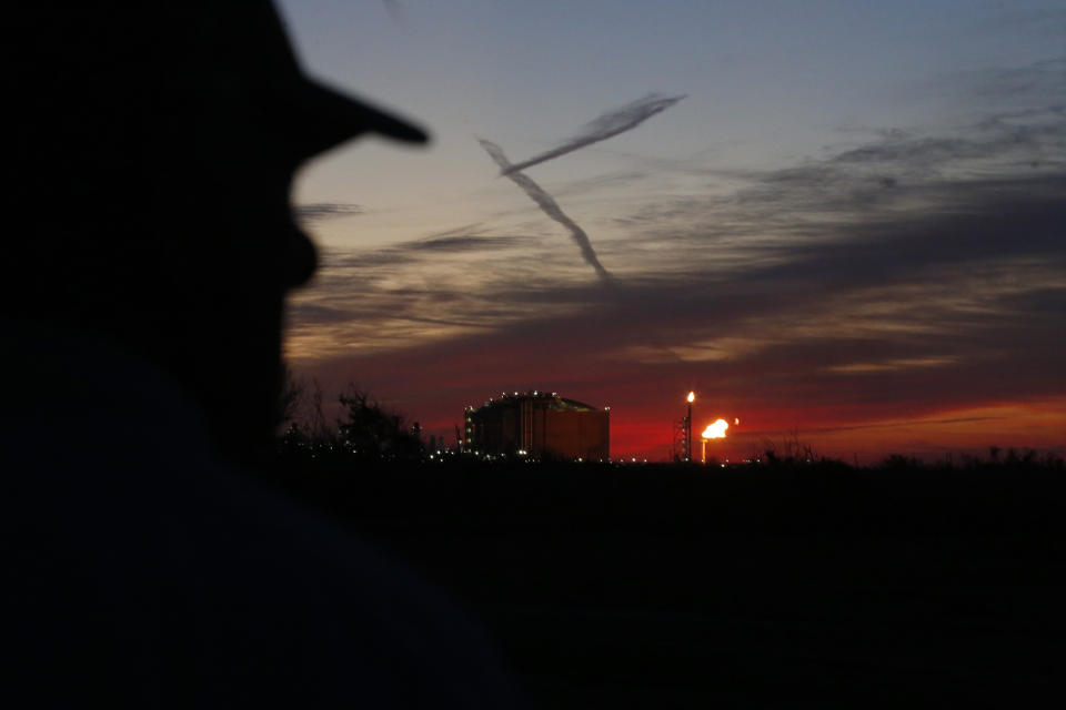 John Allaire watches flames flare from a liquefied natural gas export facility next to his oceanside property in Cameron, La., on Friday, April 1, 2022. Allaire, a retired environmental engineer in the oil and gas industry, is upset about emissions and noise and light pollution from a flare that has been burning frequently since the Venture Global LNG opened at Calcasieu Pass in recent months. "That big orange glow — it's all night and all day," he says. Allaire is fighting a second export facility, proposed by Commonwealth LNG, that would be even closer to his property. (AP Photo/Martha Irvine)