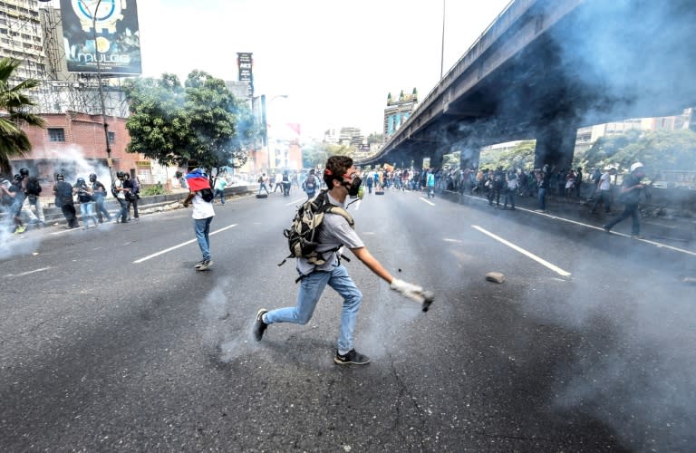 Venezuelan opposition activists chanting "No more dictatorship!" hurled stones at National Guard riot police who blocked them from marching on central Caracas