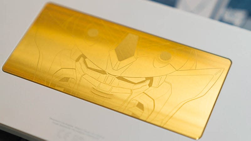 A close-up of the weighted brass medallion on the back of the Higround Summit 65 Gundam Wing keyboard.