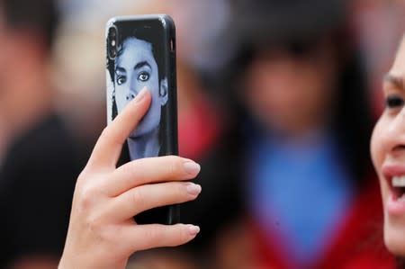 A fan sings a Michale Jackson song into her phone as people gather at Forest Lawn Cemetery ten years after the death of child star turned King of Pop, Michael Jackson, in Glendale, California,