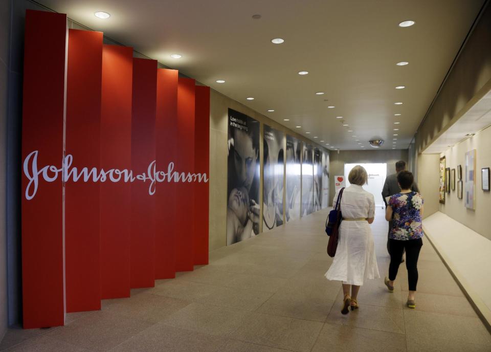 FILE - In this July 30, 2013, file photo, people walk along a corridor at the headquarters of Johnson & Johnson in New Brunswick, N.J. Amid the storm over soaring medicine prices, health care giant Johnson & Johnson says that beginning in February 2017 the company will disclose average increases in the list price and what middlemen actually pay for its prescription drugs. That will help J&J’s image more than patients initially, experts say, but it could push other drugmakers to restrain future price increases and be more transparent. (AP Photo/Mel Evans, File)