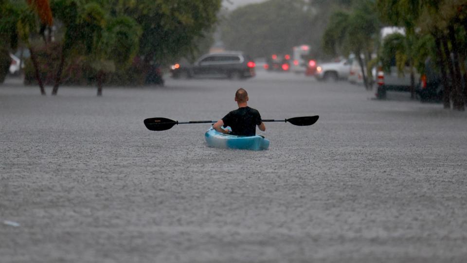 PHOTO: A person uses a kayak to float through a flooded street, June 12, 2024, in Hollywood, Fla. (Joe Raedle/Getty Images)