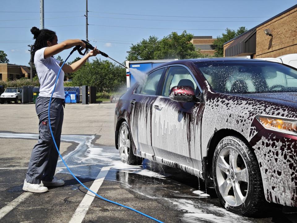 spraying down a car with a pressure washer