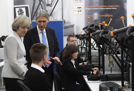 Britain's Prime Minister Theresa May and Chancellor of the Exchequer Philip Hammond speak with analytical engineers as they tour the Renishaw innovation and engineering plant in Wootton, south west England, in Britain, November 24, 2016. REUTERS/Toby Melville