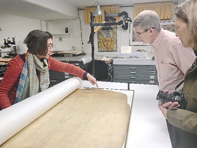 Document conservator Janice Ellis, left, points out to Washington County Historical Society President Bill Maharay and Executive Director Robyn Sumner an area of the early 19th-century plat of Hagerstown that needed special care.