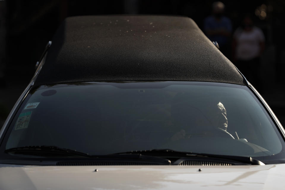 A funeral home driver maneuvers his hearse as he arrives at San Nicolas Tolentino cemetery and crematorium in the Iztapalapa district of Mexico City, Tuesday, May 5, 2020. Iztapalapa has the most confirmed cases of the new coronavirus within Mexico's densely populated capital, itself one of the hardest hit areas of the country with thousands of confirmed cases and around 500 deaths. (AP Photo/Rebecca Blackwell)