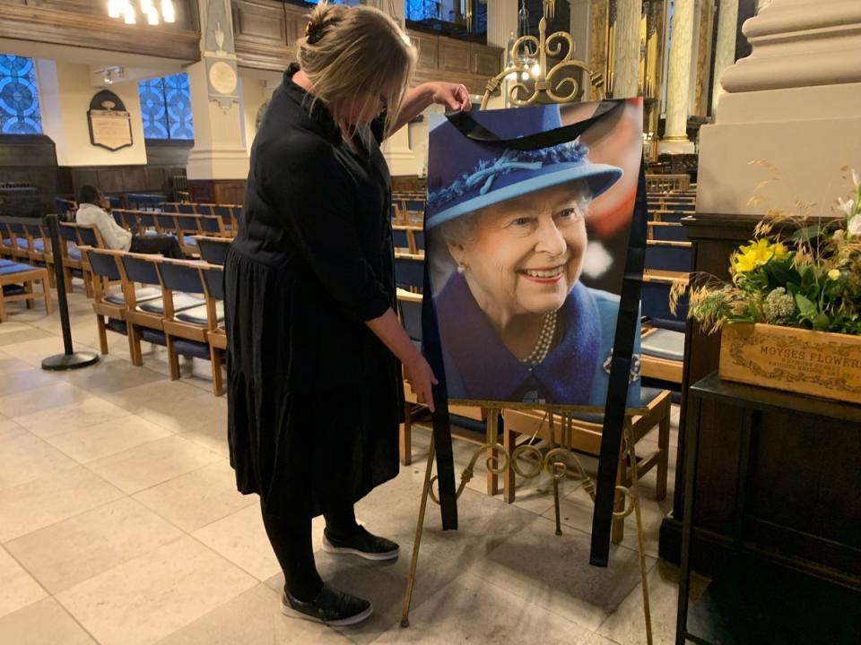 Anna Pitt, chief executive of Birmingham’s St Philip’s Cathedral putting out a picture of Queen Elizabeth II following the announcement of her death (Richard Vernalls/PA) (PA Wire)