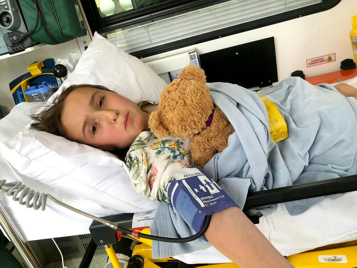 Georgie Gibbs in the ambulance after being scaled with tea. (SWNS)