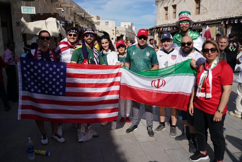 USA and Iran fans pose for a photograph at the souq in Doha. (PA)