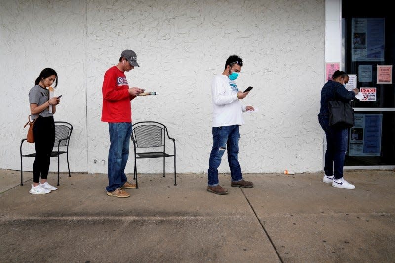 FILE PHOTO: People who lost their jobs wait in line to file for unemployment following an outbreak of the coronavirus disease (COVID-19), at an Arkansas Workforce Center in Fayetteville, Arkansas, U.S. April 6, 2020. REUTERS/Nick Oxford -/File Photo