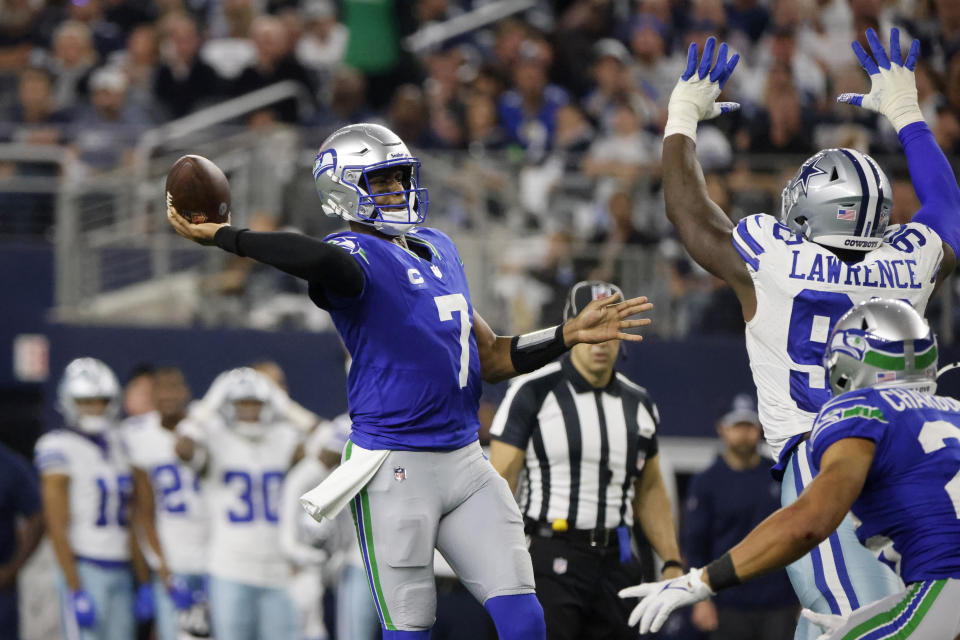 Seattle Seahawks quarterback Geno Smith (7) throws a touchdown pass to DK Metcalf, not pictured, under pressure from Dallas Cowboys defensive end DeMarcus Lawrence (90) in the second half of an NFL football game in Arlington, Texas, Thursday, Nov. 30, 2023. (AP Photo/Michael Ainsworth)
