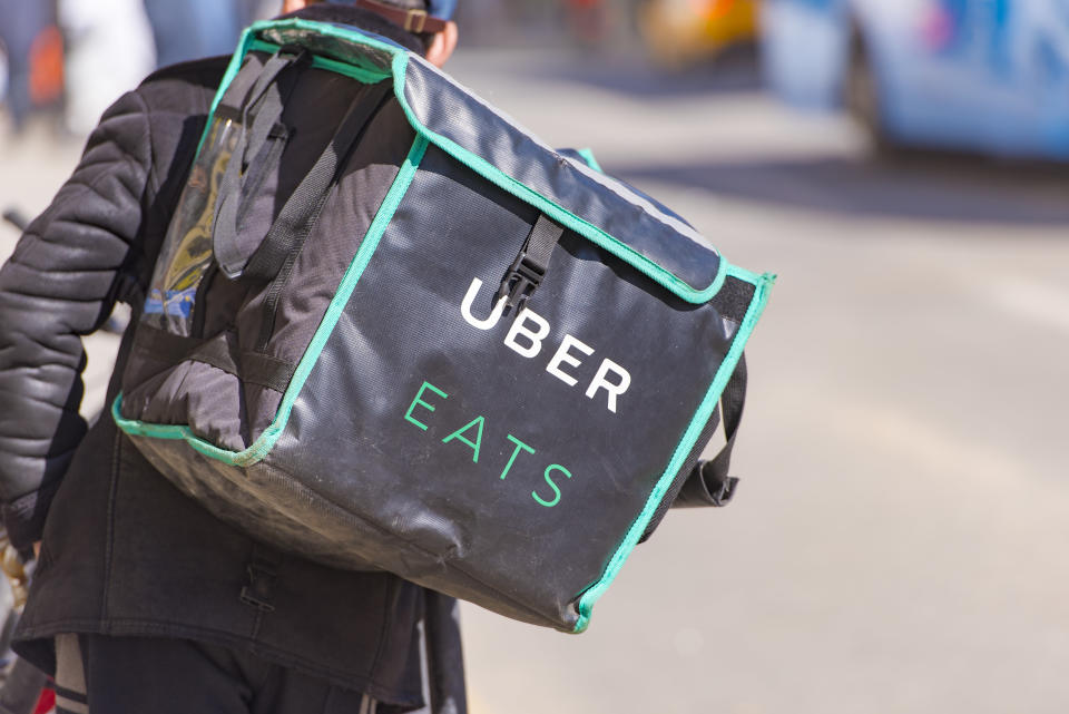 MOSCOW - APR 23: Worker with Uber Eats bicycle and a bag in a street of Moscow on April 23. 2018 in Russia