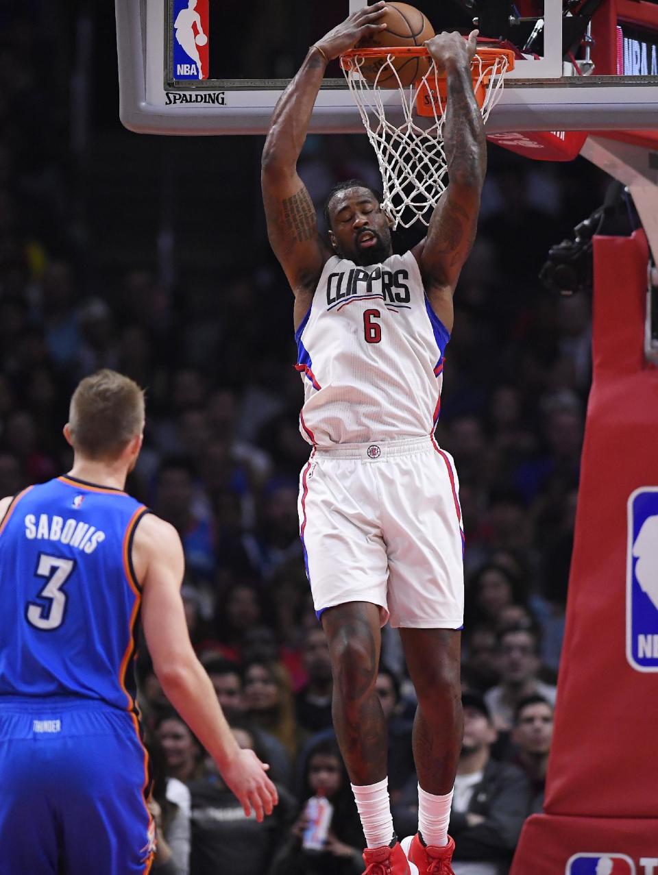 Los Angeles Clippers center DeAndre Jordan, right, dunks as Oklahoma City Thunder forward Domantas Sabonis, of Lithuania, watches during the second half of an NBA basketball game, Monday, Jan. 16, 2017, in Los Angeles. The Clippers won 120-98. (AP Photo/Mark J. Terrill)