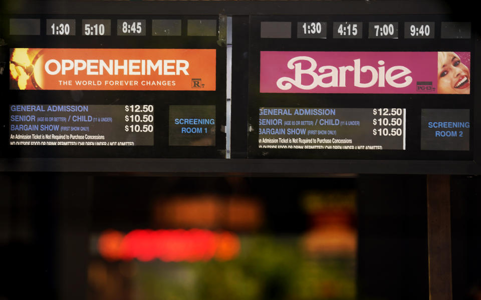 Showtimes for the films "Oppenheimer" and "Barbie" are pictured behind the box office window at the Los Feliz Theatre, Friday, July 28, 2023, in Los Angeles. (AP Photo/Chris Pizzello)