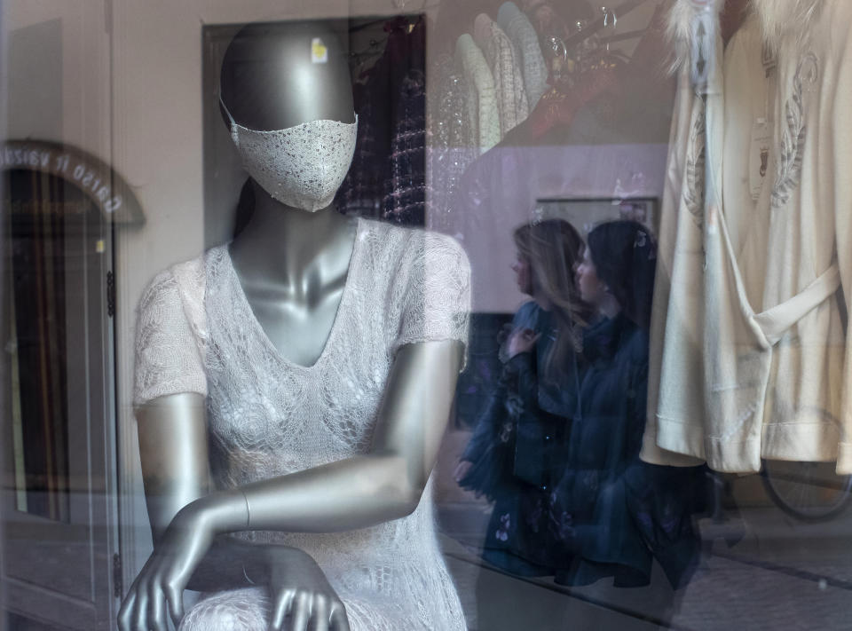 A mannequin dressed in a face mask is placed in the window of a clothing store in Vilnius, Lithuania, Friday, May 22, 2020. The Lithuanian government extended the nationwide coronavirus quarantine until May 31, but gave the green light for museums, libraries, cafes, restaurants, hairdressers and beauty salons, and retail stores in shopping malls to reopen. (AP Photo/Mindaugas Kulbis)