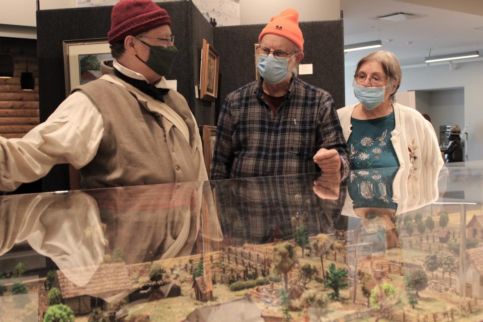 Monroe resident Ralph Naveaux (left), president of Friends of the River Raisin Battlefield, shares information about French settlers living along the River Raisin from the 1700's until the War of 1812 with Gary and Linda Greene of Davison. Marty Bertara of Wyandotte created the massive diorama.