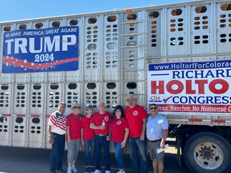 Richard Holtorf, second from right, poses with supporters next to his campaign sign-emblazoned cattle truck (The Independent)