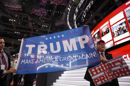 Henry Allen (R), Florida delegate and supporter of Republican U.S. presidential candidate Donald Trump, carries a Hillary (Clinton) for prison sign at the Republican National Convention in Cleveland, Ohio, U.S., July 18, 2016. REUTERS/Brian Snyder