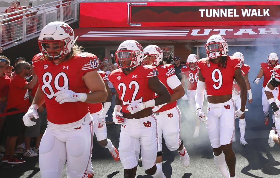 Utah cornerback Aaron Lowe (22) runs with his teammates onto the field.