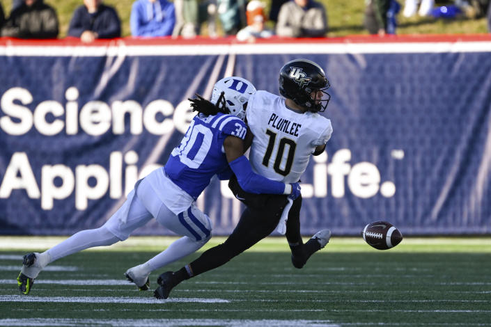 Duke defensive back Brandon Johnson forces UCF quarterback John Rhys Plumlee (10) to fumble the ball during the first half of the Military Bowl NCAA college football game, Wednesday, Dec. 28, 2022, in Annapolis, Md. (AP Photo/Terrance Williams)