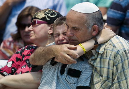 Family members mourn during the funeral for Malachi Rosenfeld in the West Bank Jewish settlement of Kochav Hashachar July 1, 2015. REUTERS/Ronen Zvulun