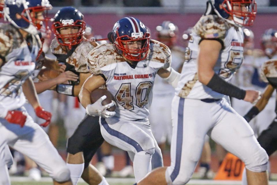 Lincoln's Tyler Durang follows his blockers during the first half of the Lions' 31-12 win over Tolman on Friday night.