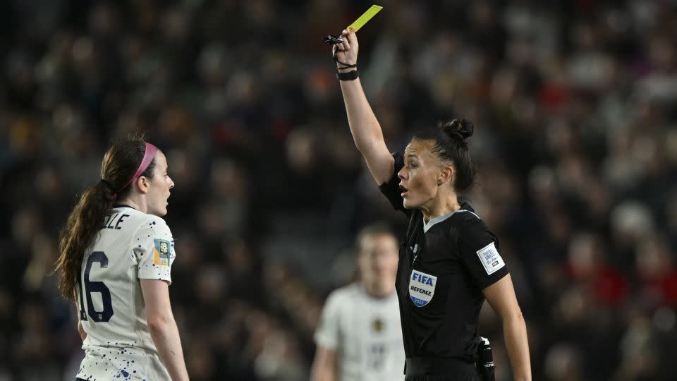 English referee Rebecca Welch (R) shows a yellow card to US midfielder #16 Rose Lavelle (L) in the match against Portugal. Lavelle will now miss her team's last-16 match on Sunday. - Saeed Khan/AFP/Getty Images