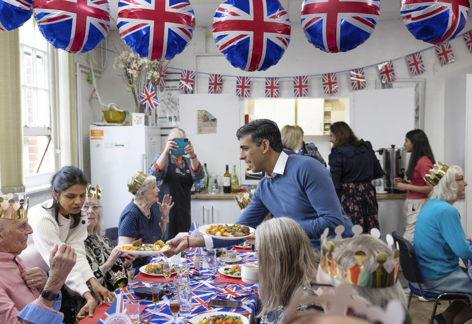 FILE - Britain's Prime Minister Rishi Sunak and his wife Akshata Murty serve the food to a community group's lunch club at Mill End Community Centre, as part of the Big Help Out, to mark the crowning of King Charles III and Queen Camilla, in Rickmansworth, England, Monday May 8, 2023. (Geoff Pugh/Pool via AP, FIle)