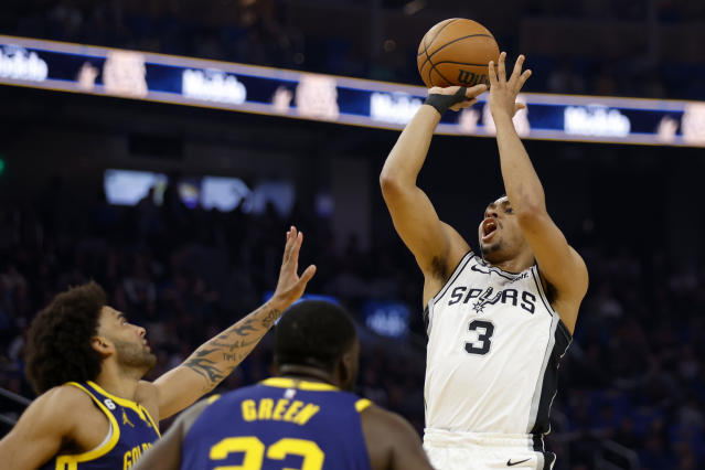 San Antonio Spurs forward Keldon Johnson (3) shoots against Golden State Warriors forward Anthony Lamb, left, during the first half of an NBA basketball game in San Francisco, Friday, March 31, 2023. (AP Photo/Jed Jacobsohn)