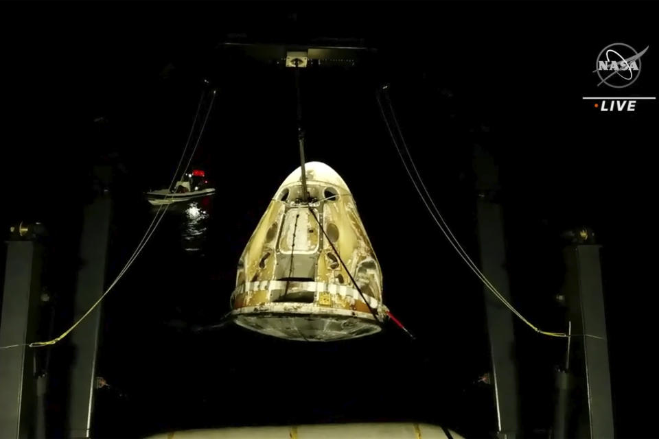 In this image made from video supplied by NASA, SpaceX Dragon space capsule is lifted out of the water after splashing down in the Gulf of Mexico early Friday, May 6, 2022. NASA’s Raja Chari, Tom Marshburn and Kayla Barron, and the European Space Agency’s Matthias Maurer undocked from the International Space Station less than 24 hours earlier. (NASA via AP)