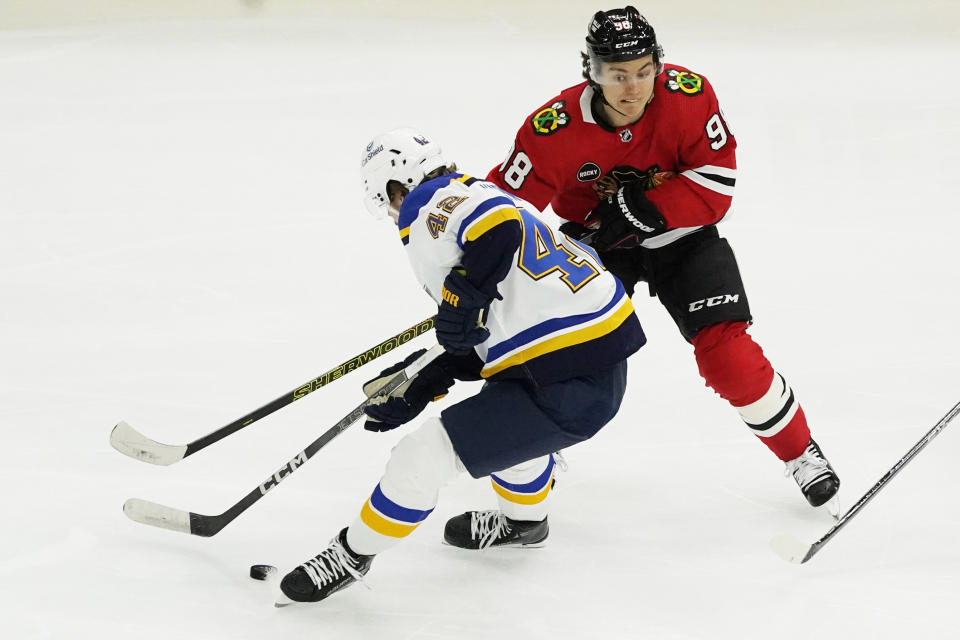 St. Louis Blues right wing Kasperi Kapanen (42) and Chicago Blackhawks center Connor Bedard (98) battle for the puck during the second period of an NHL hockey game Saturday, Dec. 9, 2023, in Chicago. (AP Photo/David Banks)