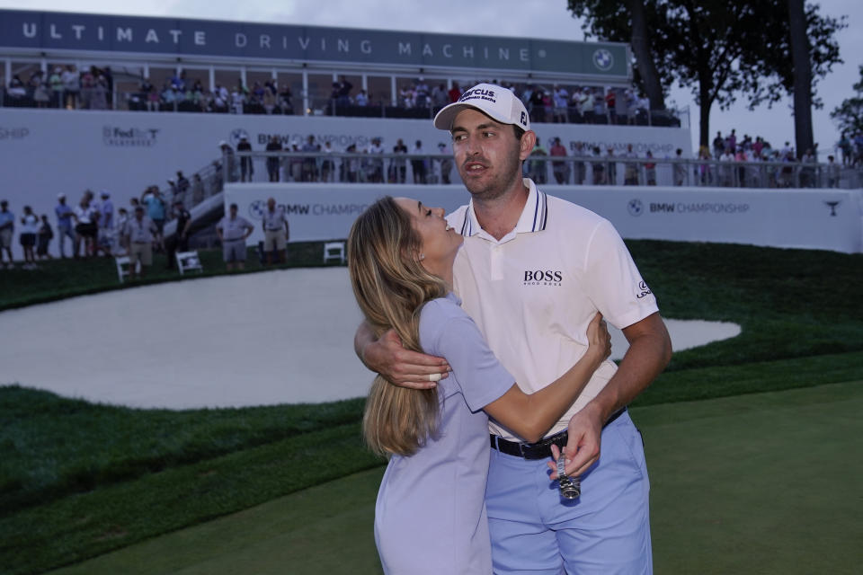 Patrick Cantlay, right, is embraced by his girlfried Nikki Guidish after he defeated Bryson DeChambeau in a six-hole playoff during the final round of the BMW Championship golf tournament, Sunday, Aug. 29, 2021, at Caves Valley Golf Club in Owings Mills, Md. (AP Photo/Julio Cortez)