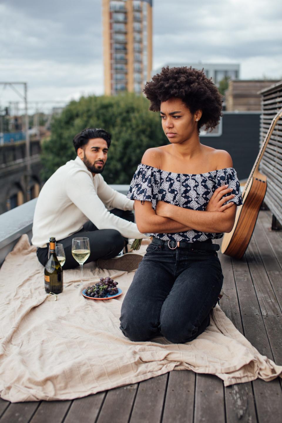 Upset Black woman facing away from her partner with her arms crossed 